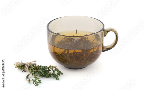 Cup of green tea with a bundle of herbs