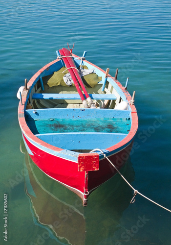 Fototapeta Coloured rowboat in clear sea.