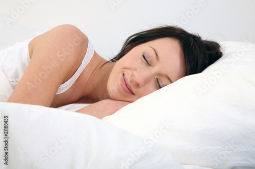 junge Frau liegt im Bett und lächelt
