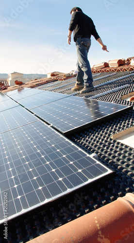 Ouvrier sur un toit installant des panneaux solaires