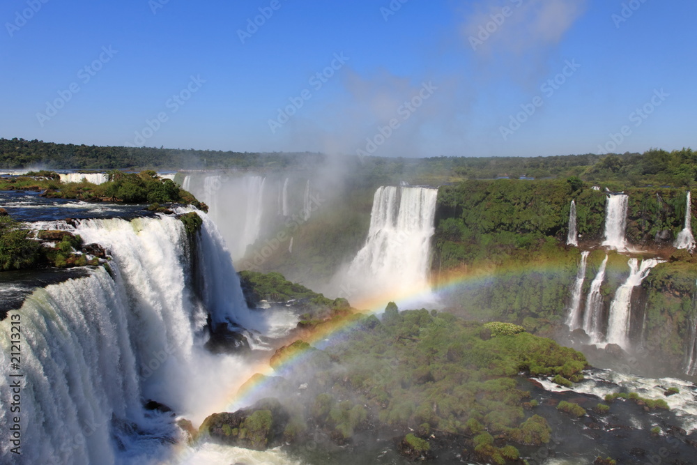 Iguazu waterfalls with rainbow on a sunny day.