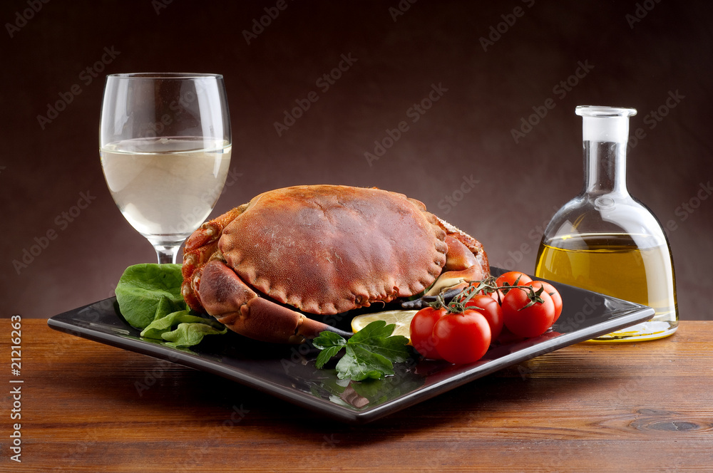crab with tomatoes  glass of wine and bottle of oil