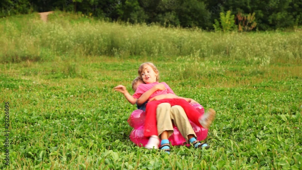 boy and girl play fool sitting on an inflatable armchair boy and girl play fool sitting on an inflatable armchair