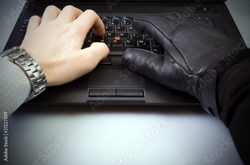 Businessman and hacker hands on laptop keyboard photo