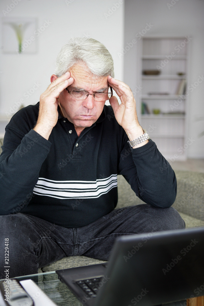 Homme senior énervé devant un ordinateur portable Photos | Adobe Stock