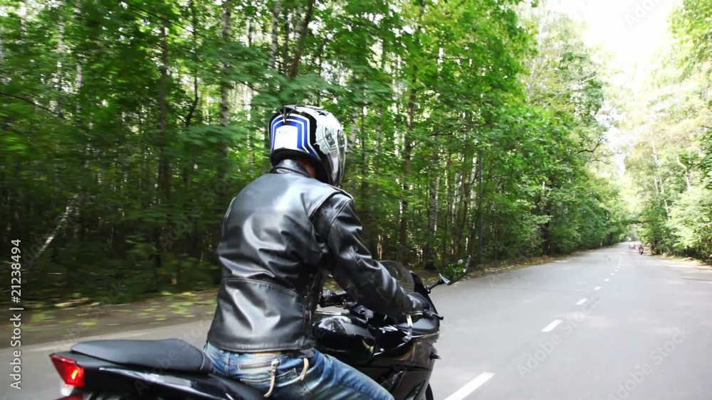 Motorcyclists moves on asphalt park road. Moving camera Motorcyclists moves on asphalt park road. Moving camera