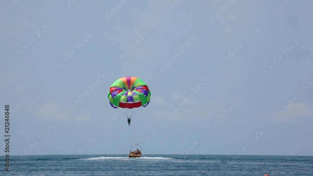 parasailing on sea, cutter have man with parachute in tow parasailing on sea, cutter have man with parachute in tow