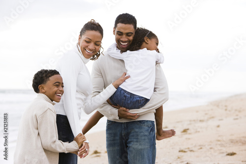 Happy African-American family with two children on beach photo