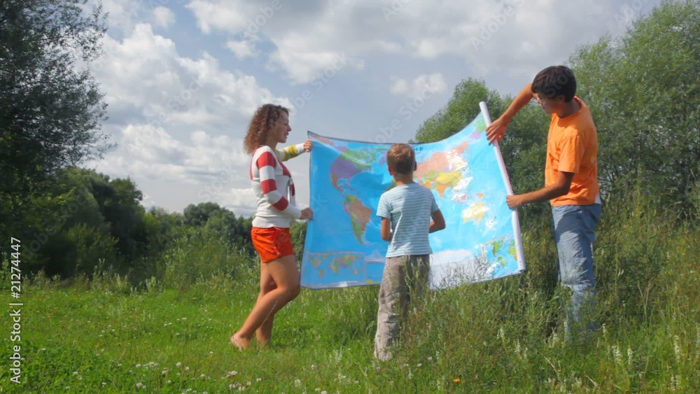 man and woman rolling up political map and giving to boy in park man and woman rolling up political map and giving to boy in park
