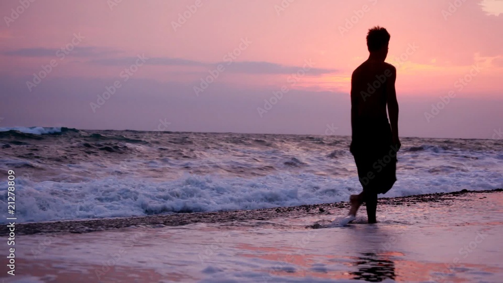 silhouette of man walking from camera on beach, sunset silhouette of man walking from camera on beach, sunset