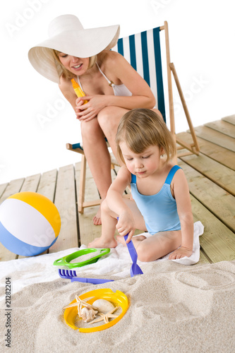 Beach - Mother with child playing with toys in sand photo