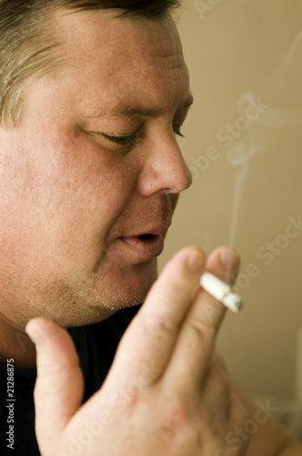 Man smoking cigarette over black
