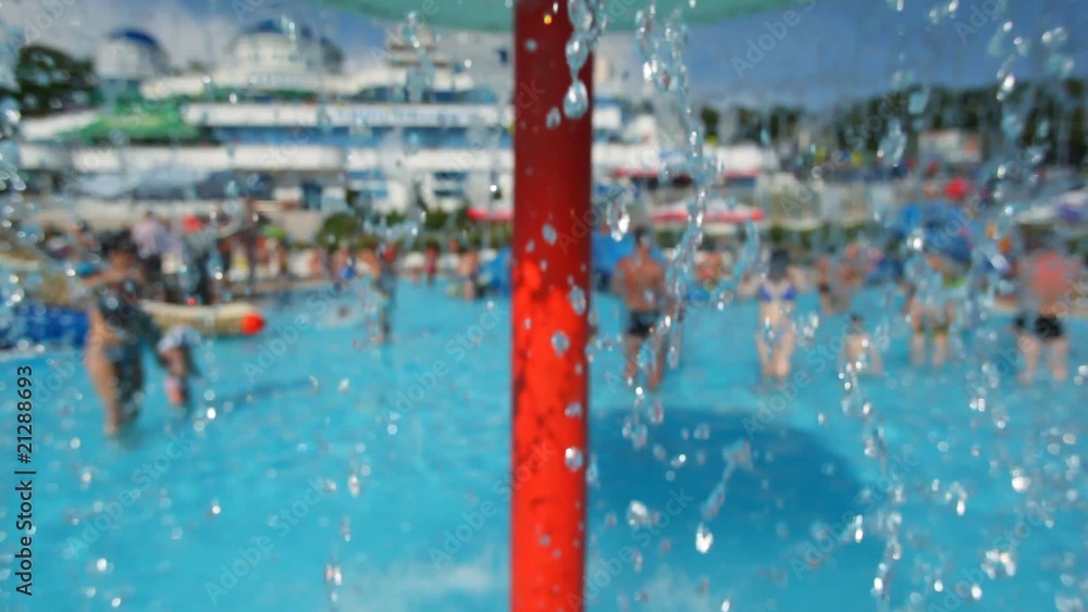 people in water park, focus on falling water in foreground people in water park, focus on falling water in foreground