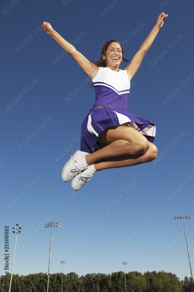 cheerleader jumping mid air low angle view (low angle view) cheerleader jumping mid air low angle view (low angle view)