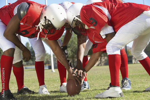 football players in huddle around ball © moodboard