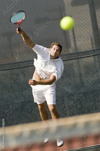 man serving tennis ball on tennis net © moodboard