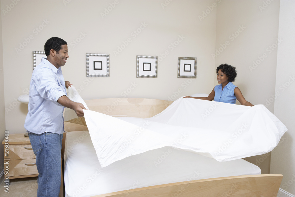 couple making bed together couple making bed together