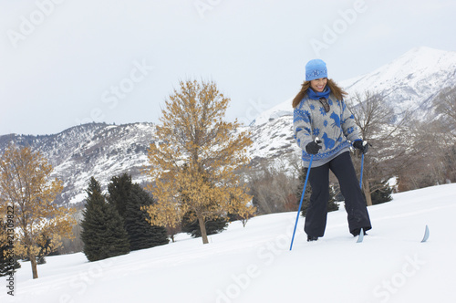 woman cross-country skiing in snow covered field