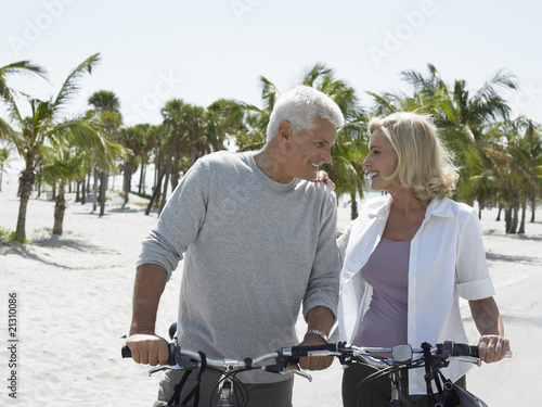 senior couple on bicycles on tropical beach