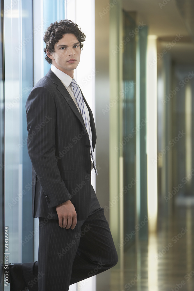 businessman standing in office corridor portrait businessman standing in office corridor portrait