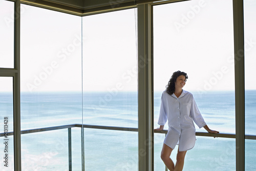 woman standing on balcony smiling © moodboard