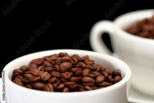 Two white cups, full of coffee beans