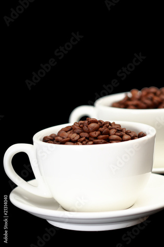 Two white cups  full of coffee beans