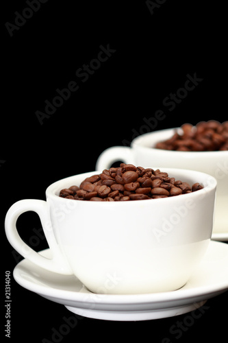Two white cups, full of coffee beans