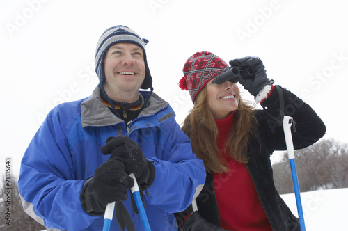 couple on skis woman using binoculars half length