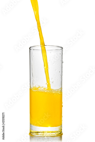 orange juice poring into glass isolated on white