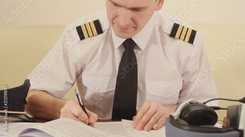 Airline pilot filling in and checking papers