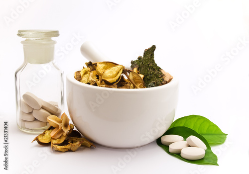 White mortar and pestle. Herbals, pills and green leaves.