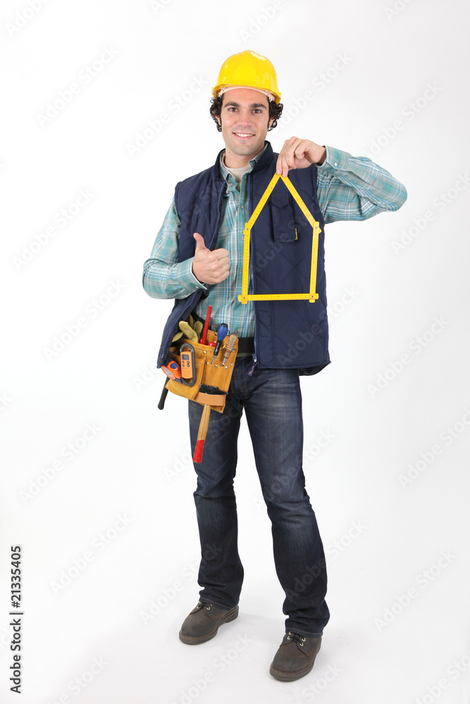 Professionnel du bâtiment satisfait avec un mètre pliant Professionnel du bâtiment satisfait avec un mètre pliant