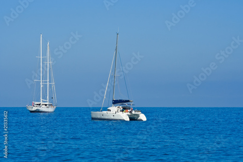 Yacht and catamaran on blue sea