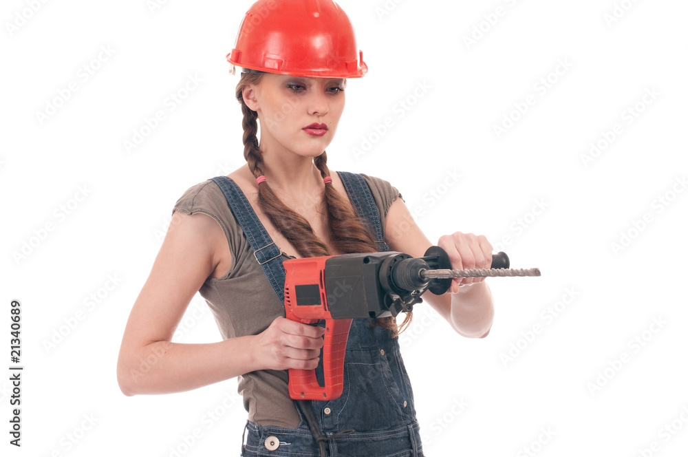 Young playful woman in jeans coverall holding perforator drill Young playful woman in jeans coverall holding perforator drill