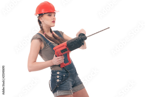 Young playful woman in jeans coverall holding perforator drill