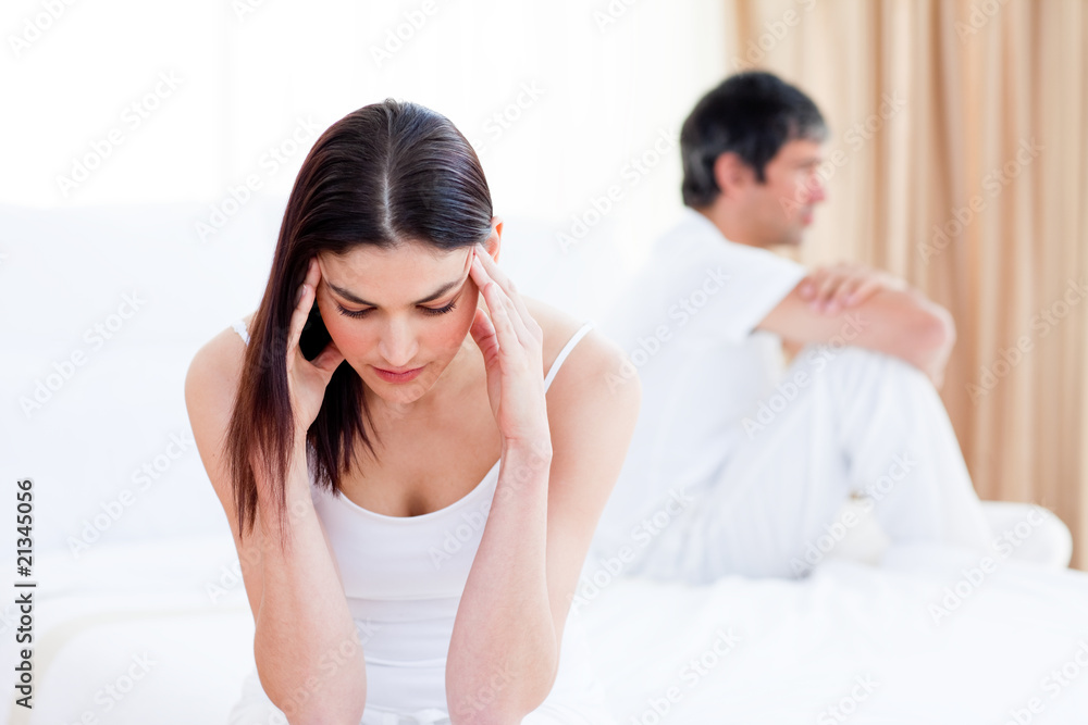 Sad couple having an argument sitting on bed Sad couple having an argument sitting on bed