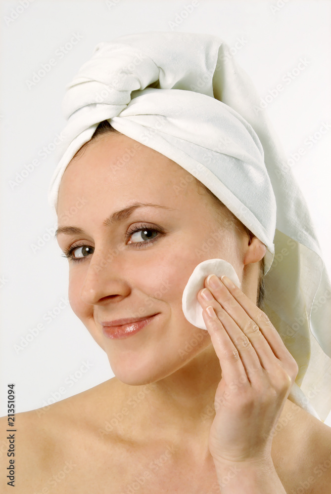 Young lovely lady applying moisturizer to her skin