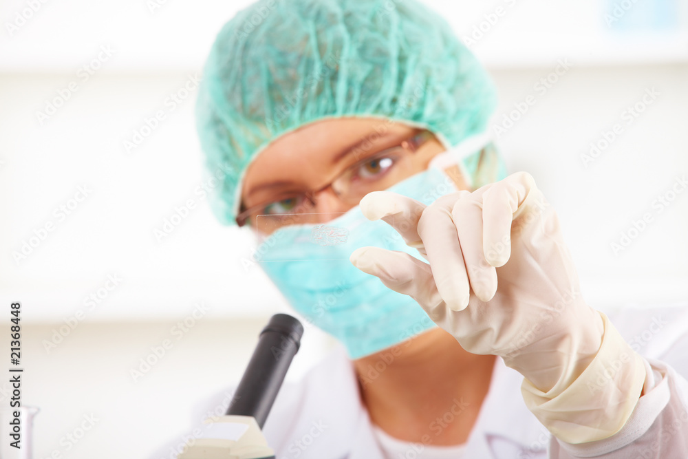 Scientific researcher using a microscope in a laboratory Scientific researcher using a microscope in a laboratory