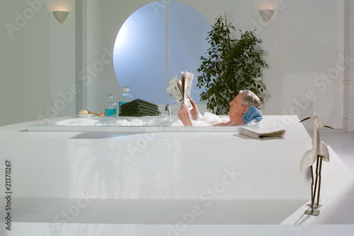 Baden, Opa in der Badewanne liest Zeitung