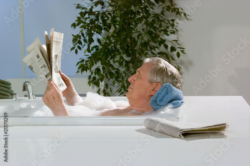 Baden, Opa in der Badewanne liest Zeitung