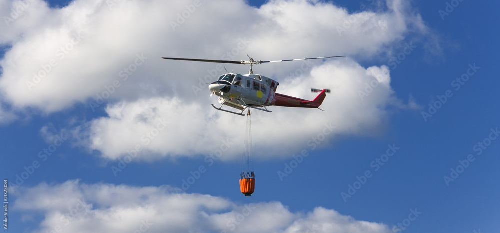 Fire fighting helicopter with waterbag on his way to combat the Fire fighting helicopter with waterbag on his way to combat the