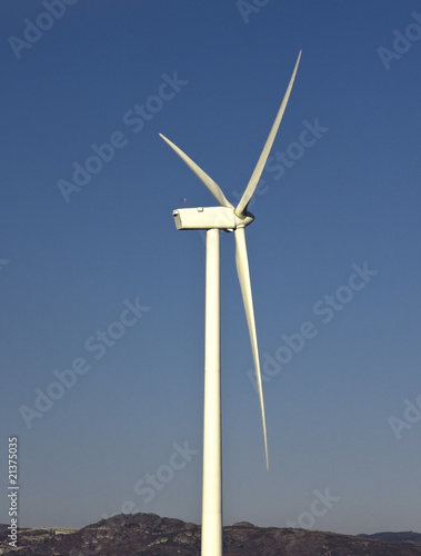 windmil in the top of a montain with blue sky, alternative energ