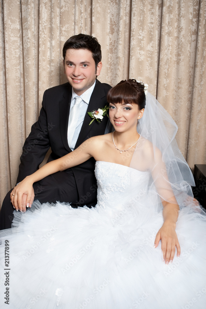 portrait of smiling bride and groom in studio