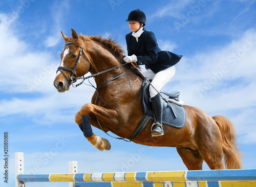 Obraz na plátne Equestrian jumper - Young girl jumping with sorrel horse