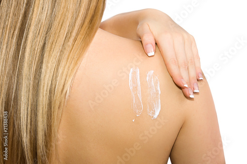 Causasian blonde woman creaming her back