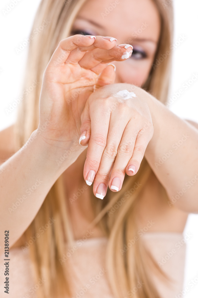 Naklejka premium Causasian blonde woman creaming hands and palms, french nails
