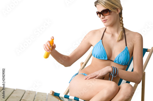 Beach - Young woman in bikini apply suntan lotion