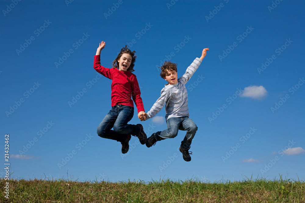 Girl and boy jumping, running against blue sky Girl and boy jumping, running against blue sky