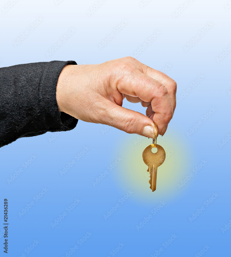Close up of hand holding key isolated on background
